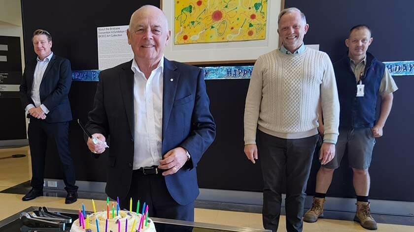 Bob O'Keeffe cuts the Centre's 25th birthday cake, other staff in background
