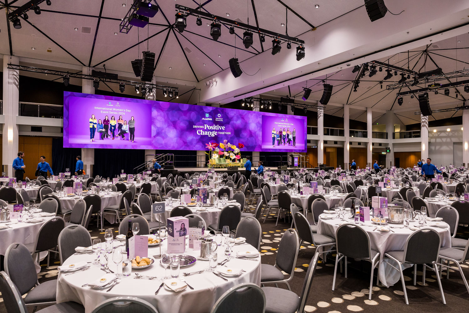A large event room with many round tables