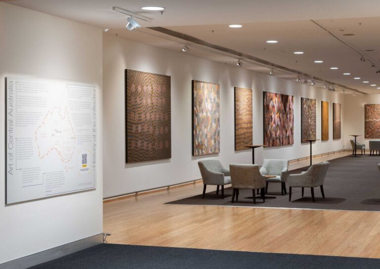 A gallery displays the Art of Central Australia with colorful paintings from Australia adorning the walls.