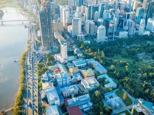 The Brisbane aerial view showcases a vibrant cityscape with a winding river and lush green spaces.