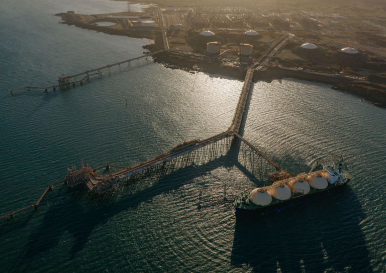 An aerial view shows the North West Shelf with a LNG carrier docked at a pier.