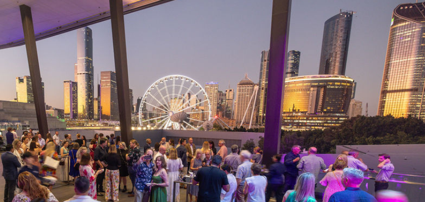 The Sky Room Terrace hosting a cocktail party with guests enjoying a golden, sunset city skyline.