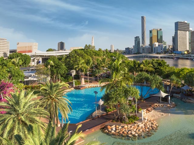 The SouthBank Beach is a beautiful urban oasis in Brisbane with lush greenery and clear blue waters.