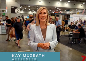 An image of Chanel 7's presenter Kay McGrath facing the camera with the Home Show exhibition taking place in the background.